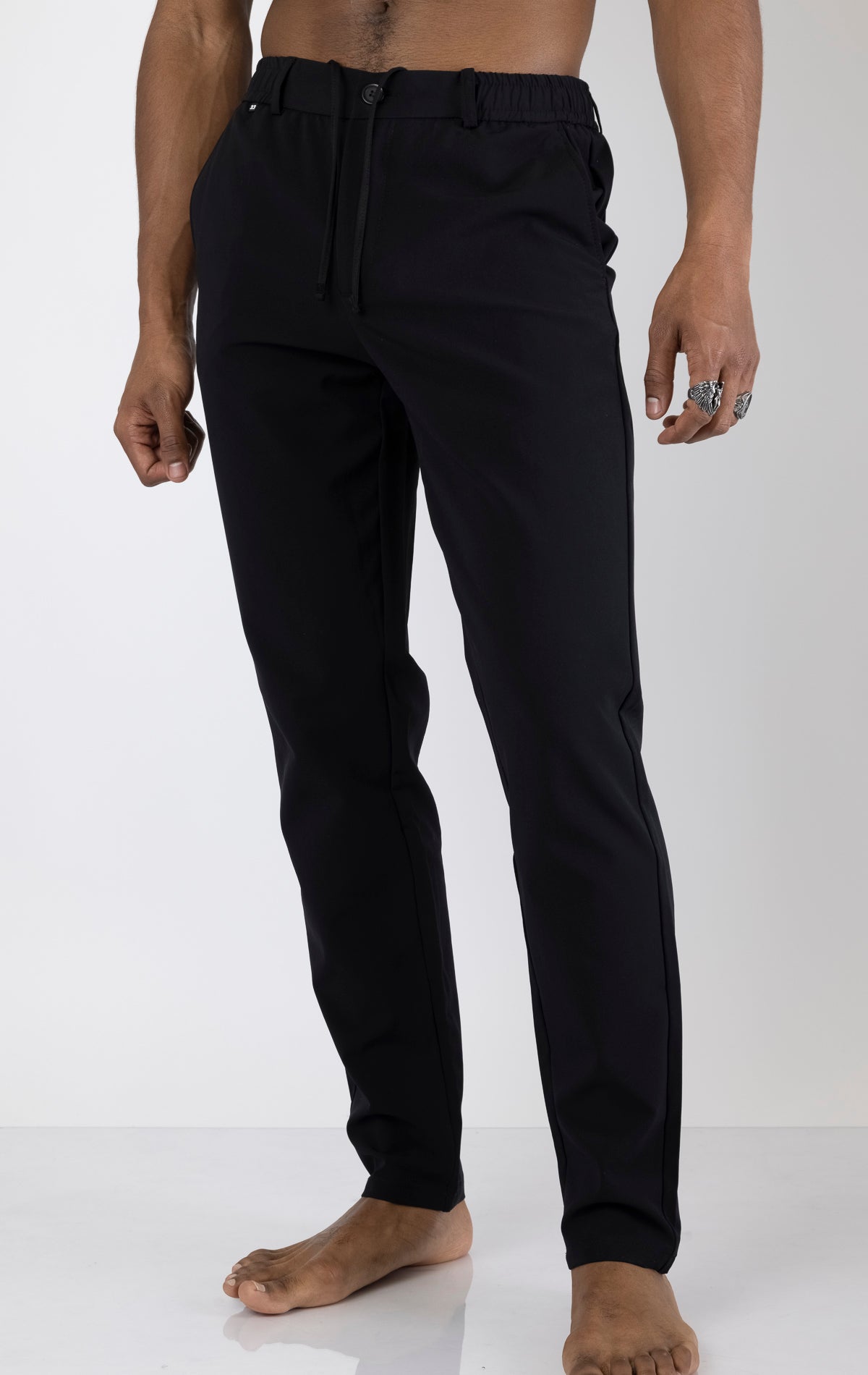 Men's wrinkle-free tapered travel pants in black. The pants are made from a blend of polyamide (88%) and elastane (12%) and feature a tapered fit, wrinkle-resistant fabric, and multiple pockets.