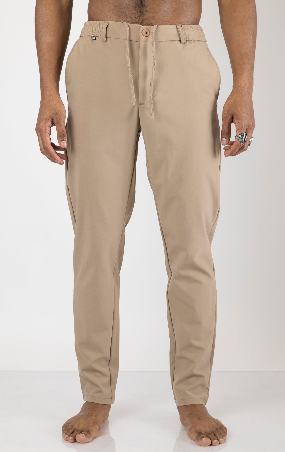 Men's wrinkle-free tapered travel pants in camel color. The pants are made from a blend of polyamide (88%) and elastane (12%) and feature a tapered fit, wrinkle-resistant fabric, and multiple pockets.