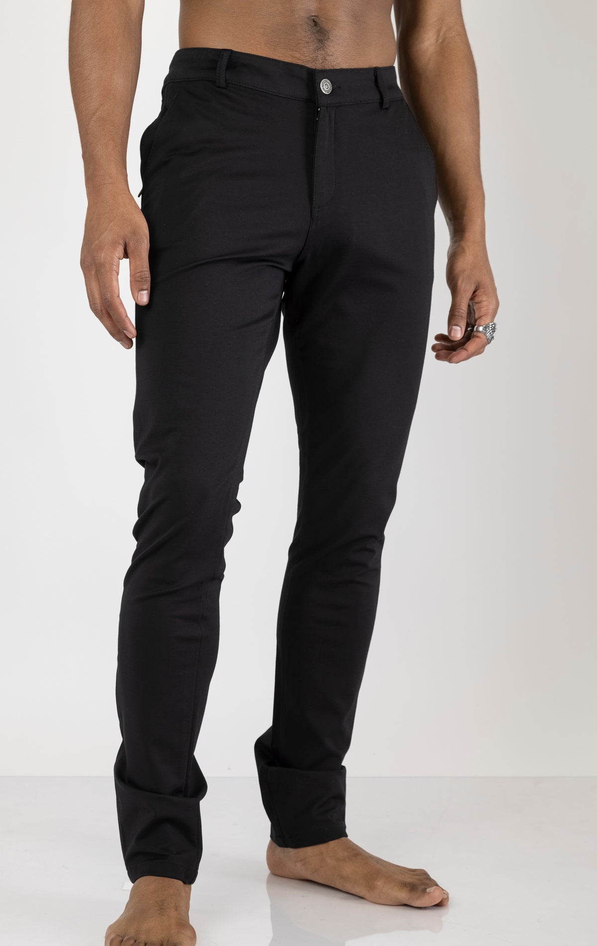 Men's casual wear pants in black. The pants are made from a blend of rayon (65%), nylon (27%), and elastane (8%) and feature a classic design with straight or tapered legs, belt loops, pockets, and a zip fly with button closure.