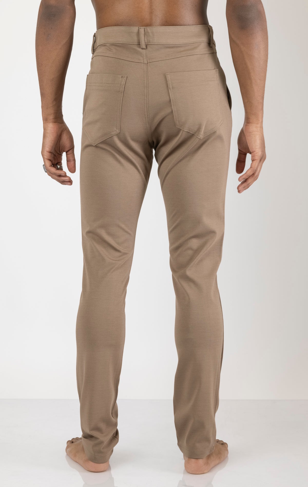 Men's casual wear pants in camel. The pants are made from a blend of rayon (65%), nylon (27%), and elastane (8%) and feature a classic design with straight or tapered legs, belt loops, pockets, and a zip fly with button closure.