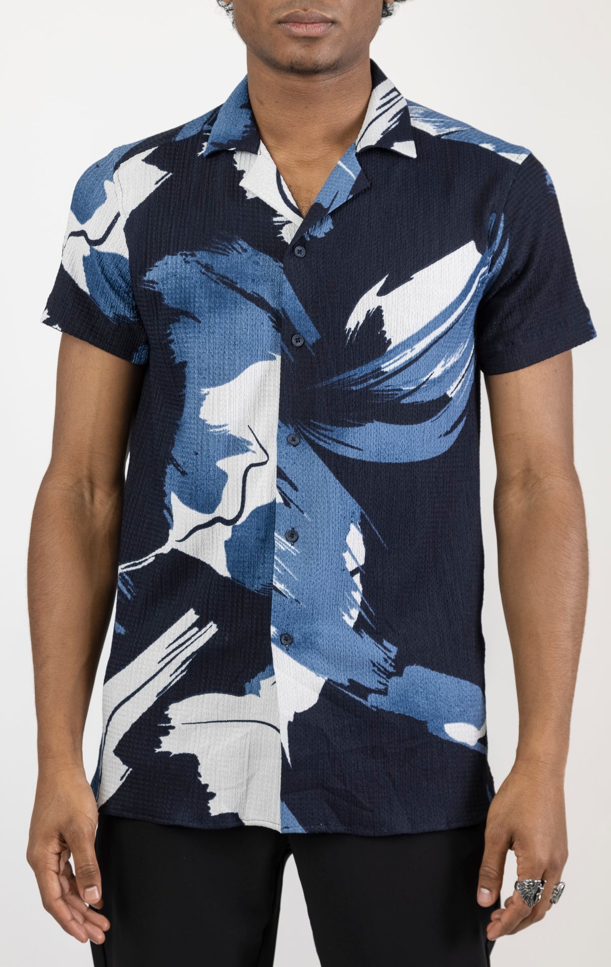 Men's short sleeve geometric pattern shirt in blue. The shirt is made from a lightweight and breathable fabric (99% polyester, 1% elastane) and features a relaxed fit, short sleeves, a classic collar, and a button-up front closure.