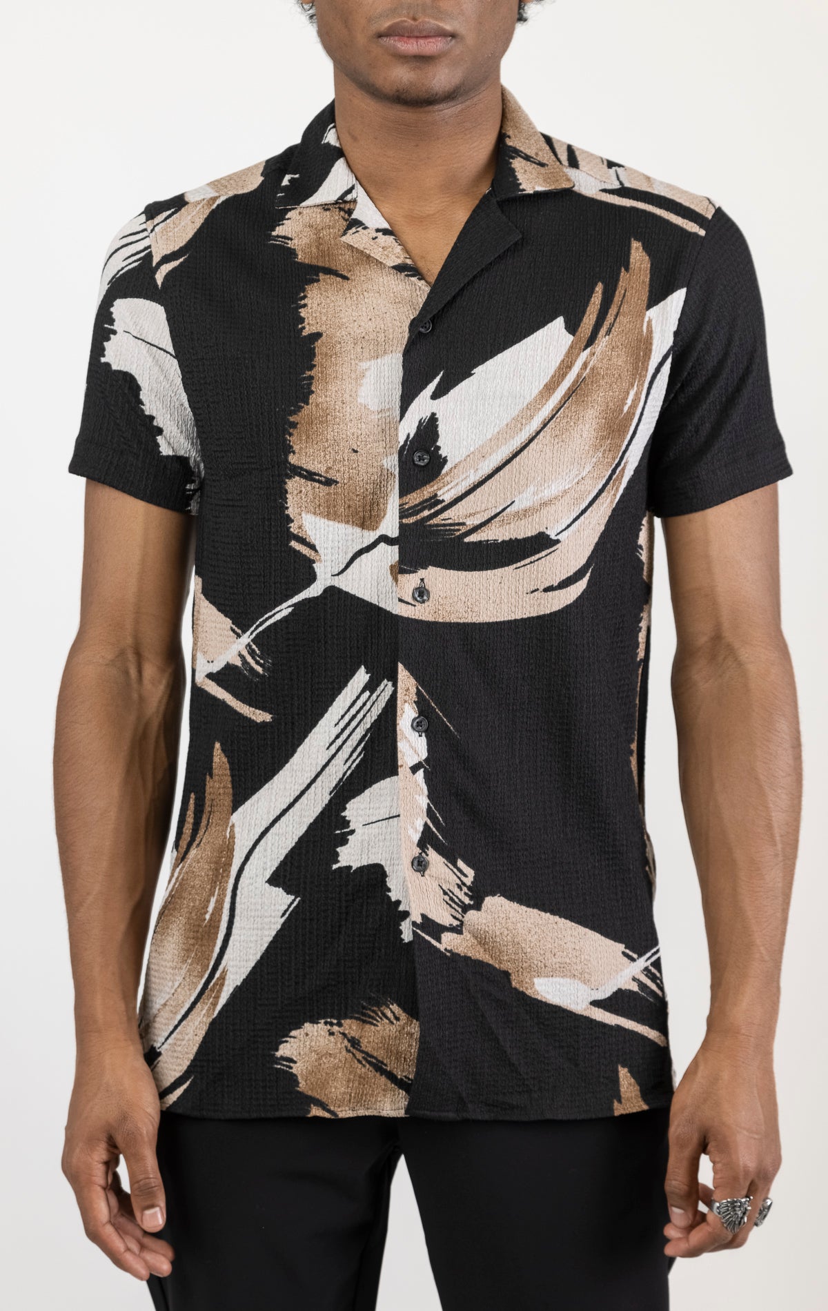 Men's short sleeve geometric pattern shirt in brown. The shirt is made from a lightweight and breathable fabric (99% polyester, 1% elastane) and features a relaxed fit, short sleeves, a classic collar, and a button-up front closure.