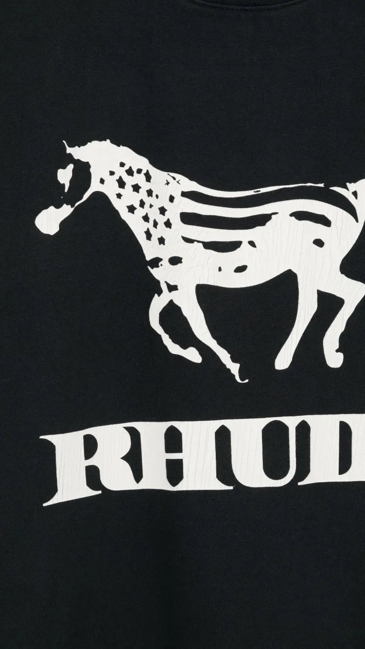 Close-up of a black sweatshirt featuring a white graphic of a running horse with the word 'RHUDE' printed below it.