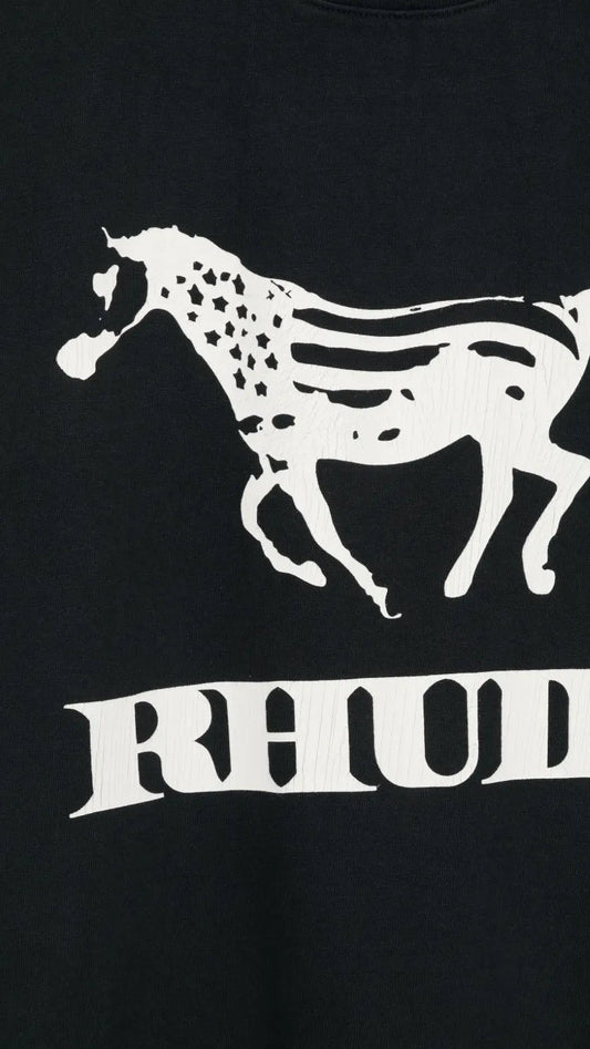 Close-up of a black sweatshirt featuring a white graphic of a running horse with the word 'RHUDE' printed below it.