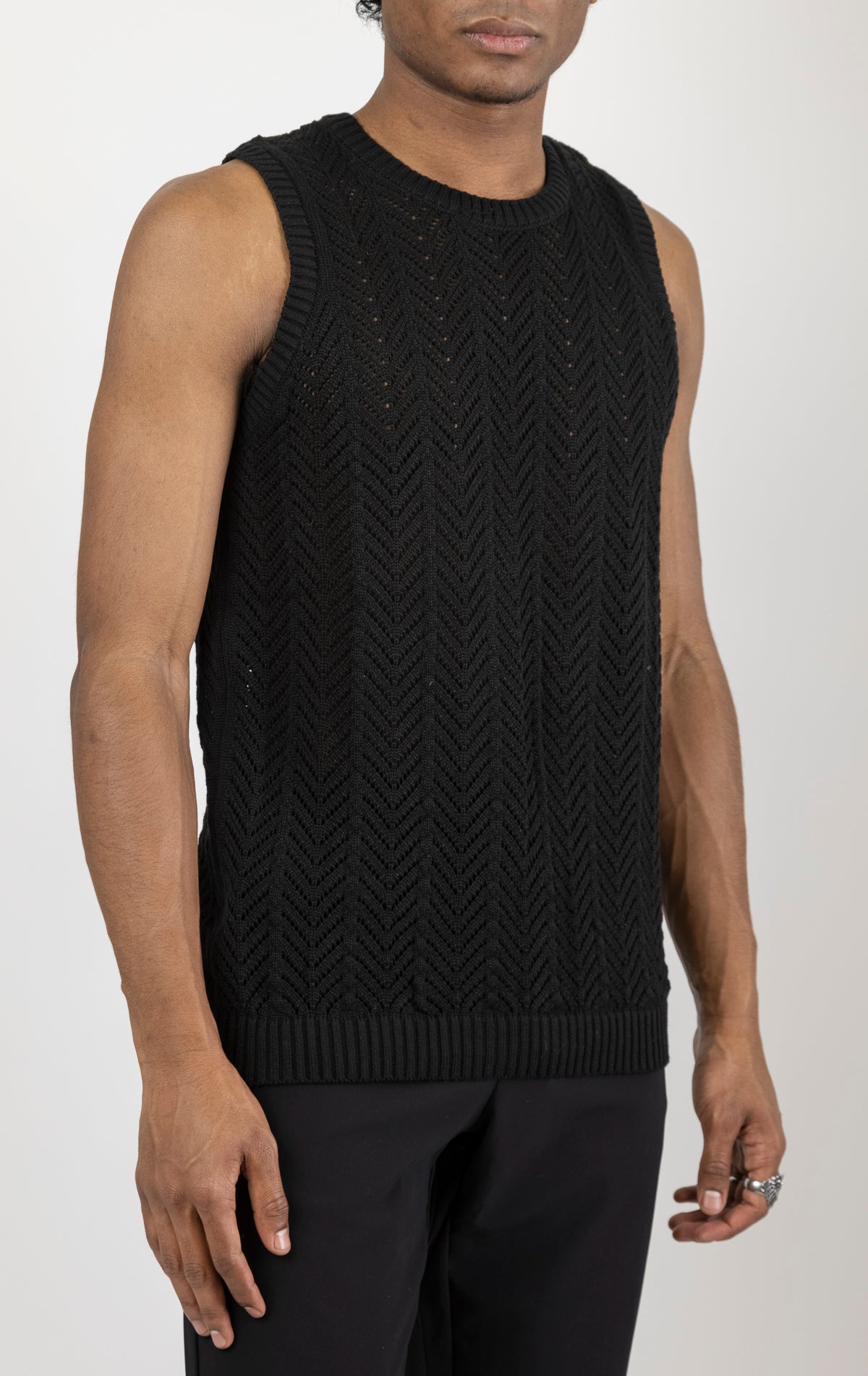 Men's knit muscle fit tank top in black. The tank top is made from a 50% cotton, 50% acrylic blend and features a muscle fit cut, sleeveless construction, and a textured knit fabric.