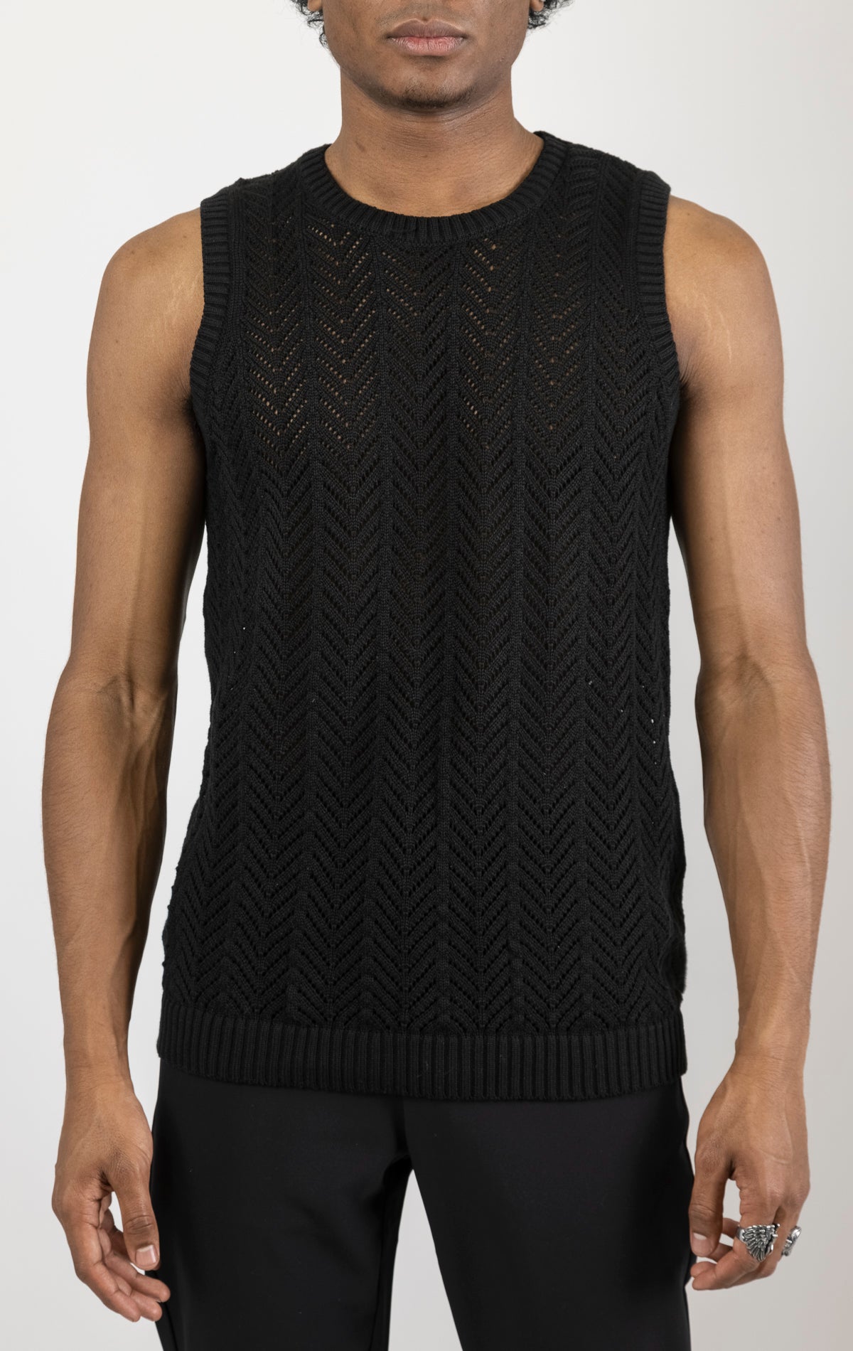 Men's knit muscle fit tank top in black. The tank top is made from a 50% cotton, 50% acrylic blend and features a muscle fit cut, sleeveless construction, and a textured knit fabric.