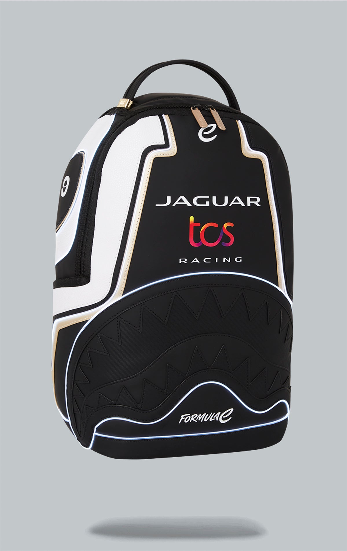 Sprayground x Formula E Jaguar backpack with built-in LED lights. Black water-resistant PVC backpack with Formula E Jaguar design. Includes laptop compartment, organizer pocket, and USB cable for charging. Note: Lithium battery inside, check with airline before travel.