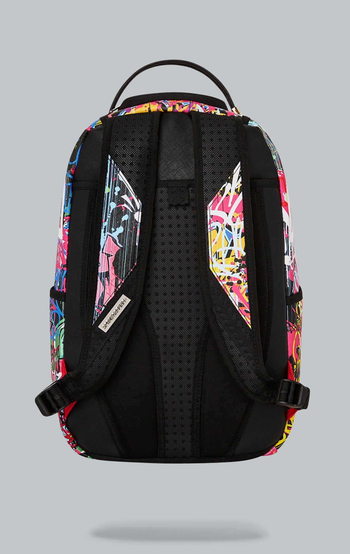 Sprayground Lower East Side Shark Backpack. The backpack is made from durable water-resistant faux leather (100%) and features a black exterior with a shark graphic. It includes a front zipper pocket, side pockets, a zippered stash pocket, a separate velour sunglass compartment, ergonomic mesh back padding, adjustable straps, gold zippers with metal hardware, and a metal 