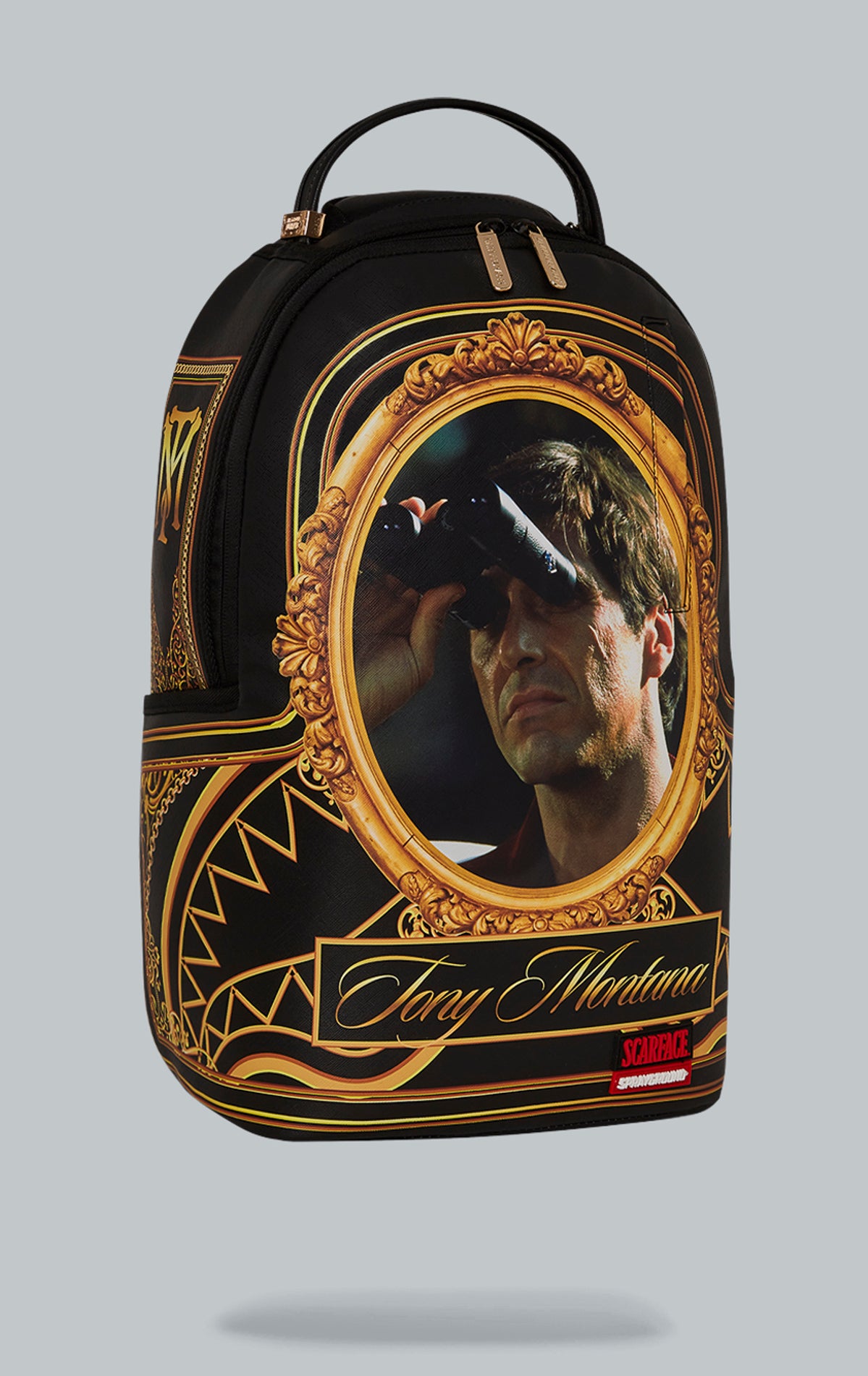 Sprayground Scarface Golden Bird Watcher Backpack. The backpack is made from durable faux leather (100% PVC) and features a Scarface-inspired design, a front zipper pocket, side pockets, a zippered stash pocket, a separate velour sunglass compartment, ergonomic mesh back padding, adjustable straps, and a slide through back sleeve that connects to carry-on luggage. The interior includes a separate velour laptop compartment and a mesh organizer pocket.