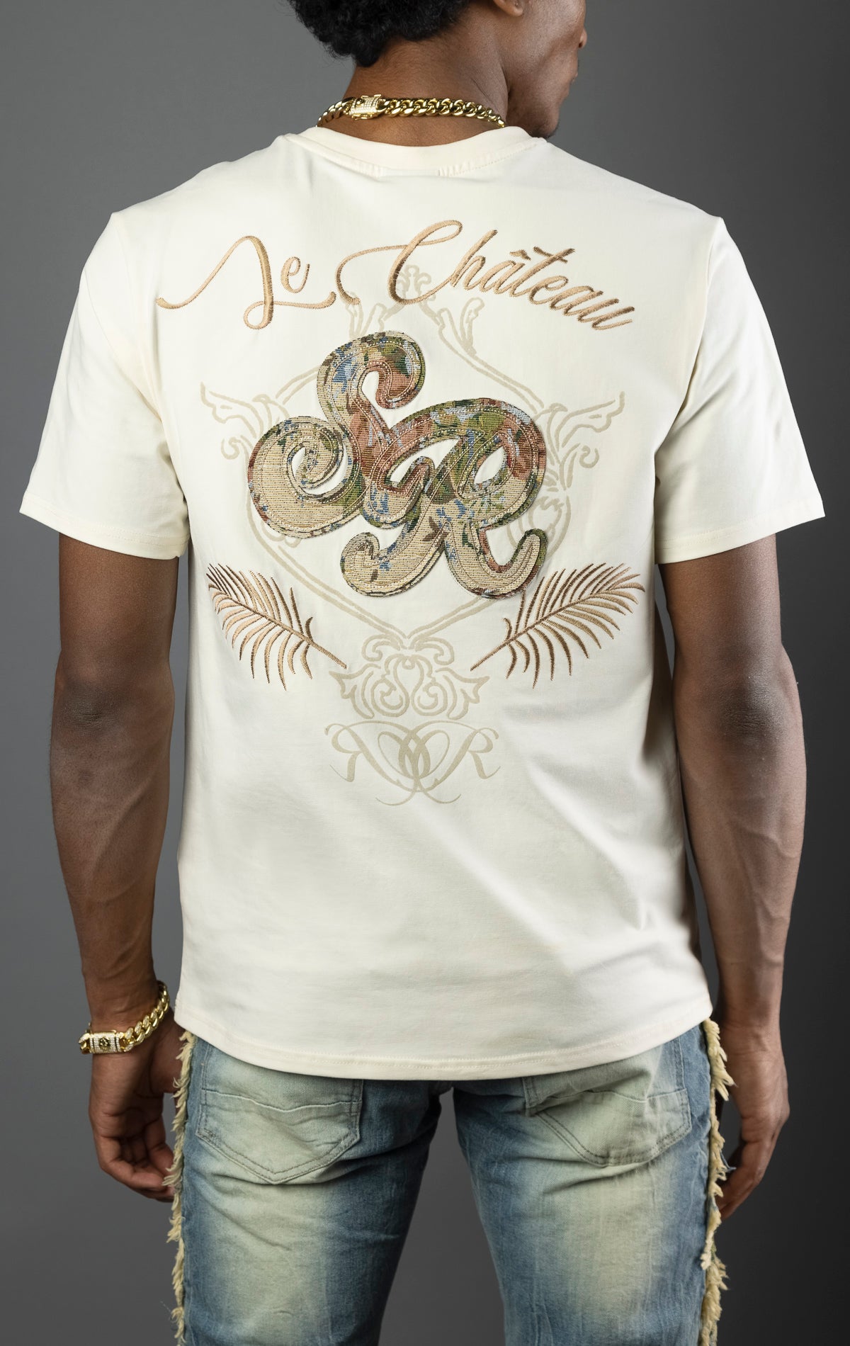 Men's t-shirt in a chalk color with a regular fit. The shirt features a tapestry design on the front left chest and back. Made from a blend of 95% cotton and 5% spandex.