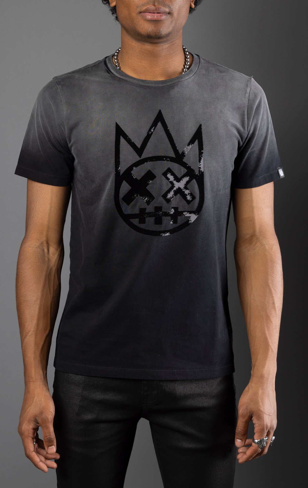 Vintage grey cotton tee with weathered look, oversized distressed felt flocking Shimuchan logo on the front, and signature 'XX' on the back.