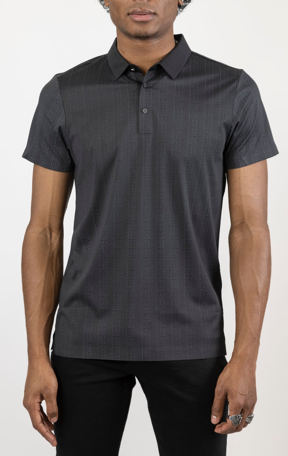 Men's versatile stretch polo shirt in black. The polo is made from an 87% nylon, 13% spandex blend and features a seamless pattern design, a classic polo collar with buttons, and short sleeves.