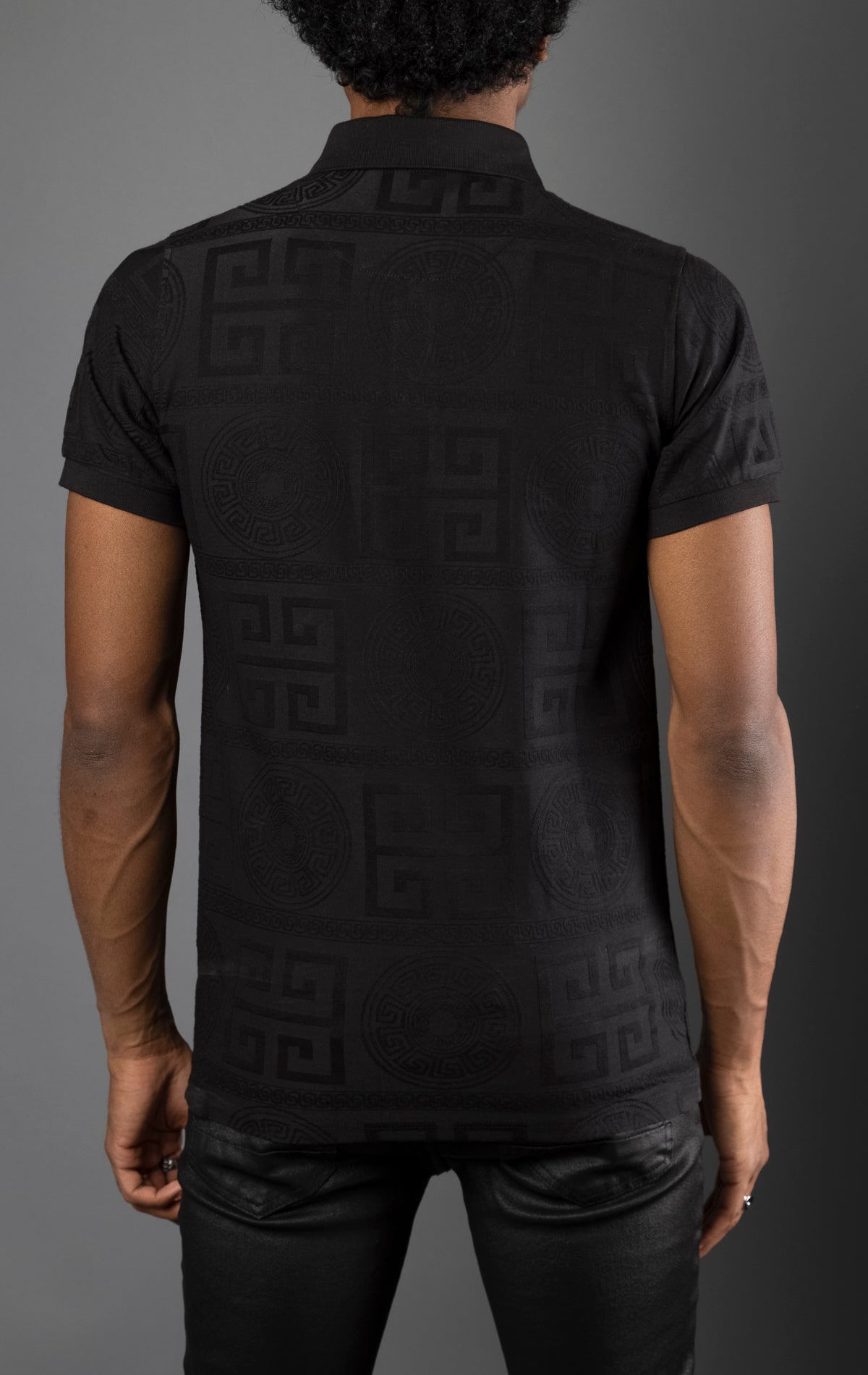 Black Men's regular-fit, short-sleeve polo shirt. The shirt features a seamless Greek pattern and a classic polo design