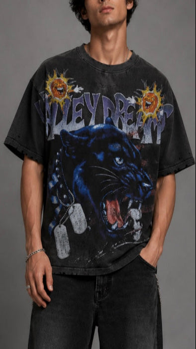 Person wearing a black t-shirt with a panther graphic and 'Valley Dream' text on a gray background
