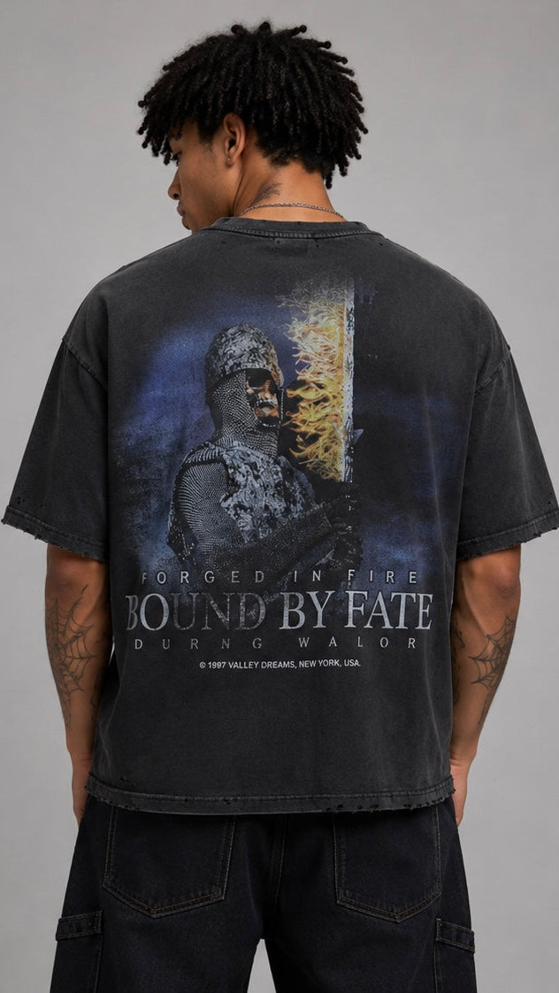 Person wearing a black t-shirt with a graphic design on the back against a gray background