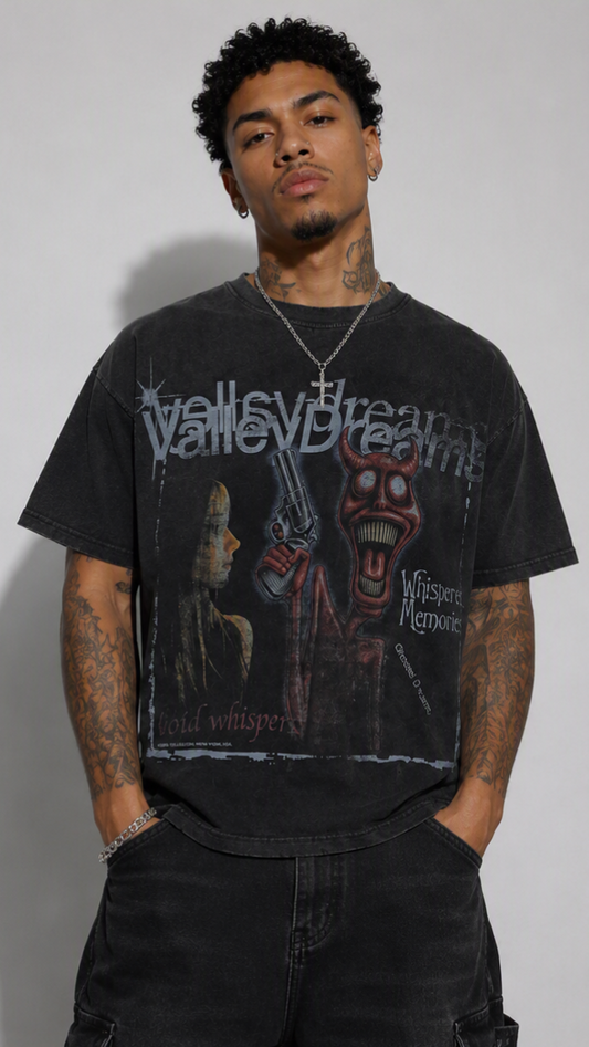 A man wearing a faded black graphic t-shirt with a 'Valley Dreams' band print, paired with black cargo pants, standing against a light gray background.