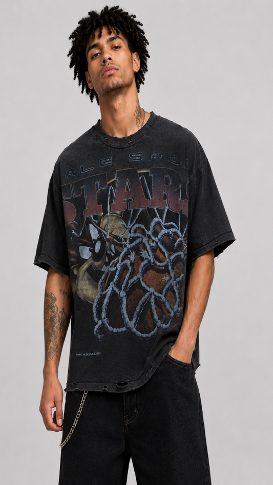 Man wearing a black graphic t-shirt with a design on a gray background