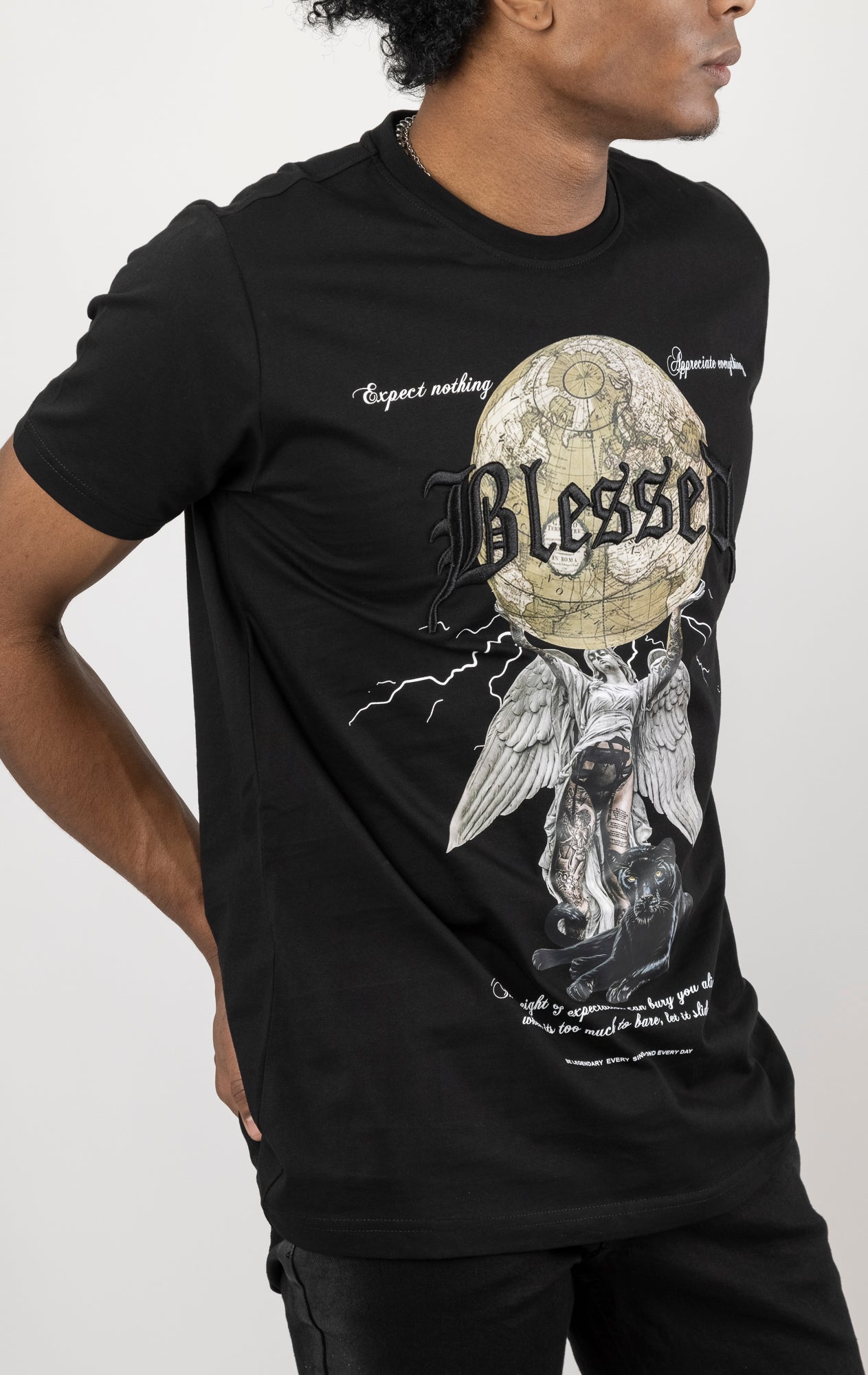 Men's regular fit t-shirt in a variety of colors. The shirt features a slightly elongated sleeve, a comfortable fit through the shoulders and body, and a "Weight of Expectations" front print with 3D embroidery.  Made from 100% cotton jersey (190gsm).  A "blessed" slogan is printed on the inner neck binding and a woven side seam tab with "blessed" is also included.