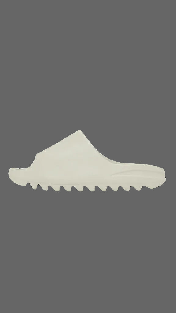 A single off-white slip-on shoe with a wavy, sculpted sole, shown in a side profile against a solid dark gray background.