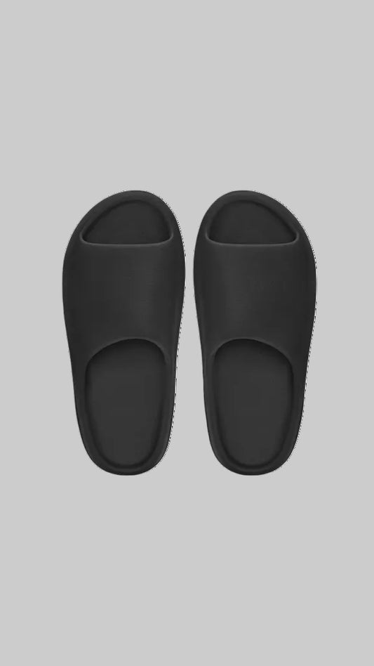 Pair of black slippers on a white background