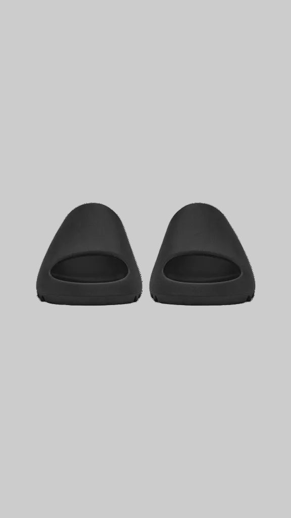 Two black slippers on a white background