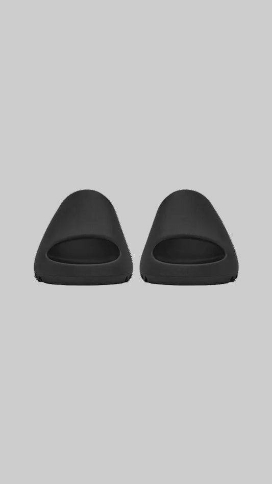 Two black slippers on a white background